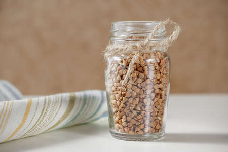 Uncooked buckwheat in glass jar. Close upの写真素材