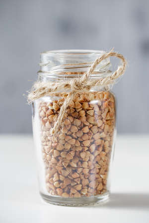 Uncooked buckwheat in glass jar. Close upの写真素材