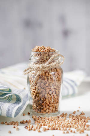 Uncooked buckwheat in glass jar. Close upの写真素材