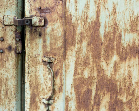 Old metal door with cracks and rust. Grunge rusted metal background. Cracked paint texture.