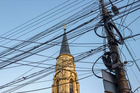 Messy electrical cables in front of the St. Michael's Church in Cluj-Napoca, Romania. Uncovered...