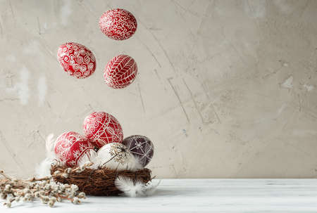 Paschal still life with flying Pysanky and pussy willow branches. Easter eggs decorated with wax resist technique, traditional for Eastern European culturesの写真素材