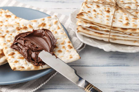 Jewish matzah bread with chocolate cream and knife. Tasty snack for Passoverの写真素材