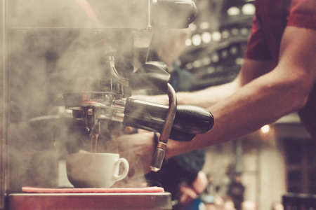 Barista makes coffee using professional coffee machine in the cafe, Shallow depth of field, pastel color toningの写真素材