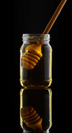 Silhouette of Honey jar with dipper on the black backgroundの写真素材