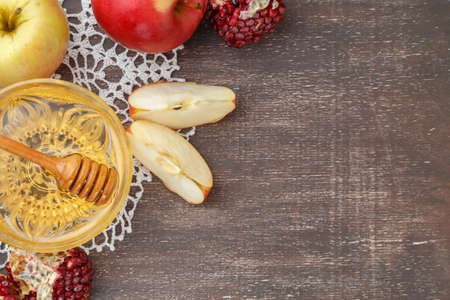 Rosh Hashanah, Jewish New Year holiday concept. Honey, apple and pomegranate on wooden table. Space for textの写真素材