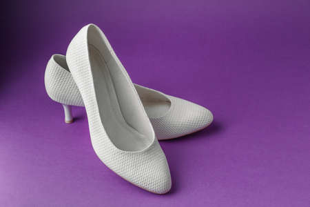 Simple white wedding shoes on purple backgroundの写真素材