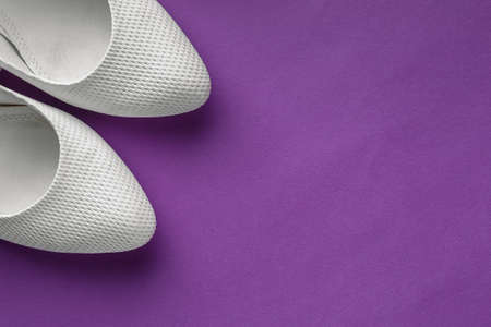 Simple white wedding shoes on purple backgroundの写真素材