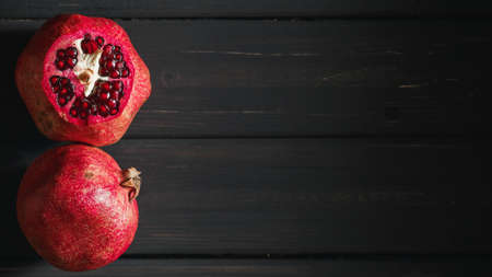 Pomegranate fruit on black wooden background. Healthy food conceptの写真素材