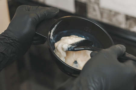 Stylist preparing a hair dye in a container, hairdresser salon conceptの写真素材