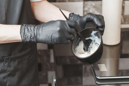 Stylist preparing a hair dye in a container, hairdresser salon conceptの写真素材
