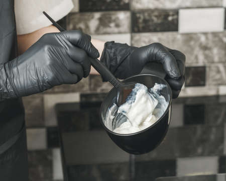 Stylist preparing a hair dye in a container, hairdresser salon conceptの写真素材