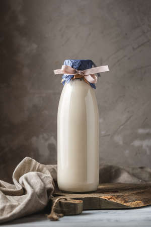 Reusable glass bottle of fresh milk on rustic backgroundの写真素材