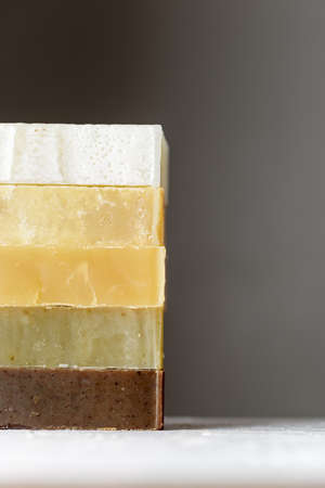 Tower stack of different kinds of handmade soaps over grey background