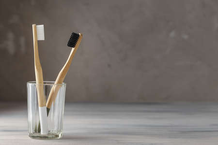 Two eco friendly bamboo tooth brushes in a glass. Zero Waste concept. Copy space for textの写真素材