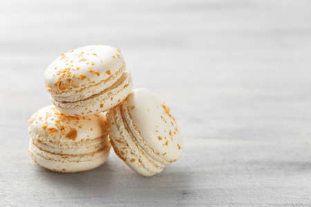 French macarons. Stack of white praline macaroons on grey background. Copy space