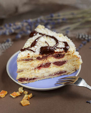 A piece of delicious summer cherry cake on a lavender color plate with cup of tea, closeupの写真素材