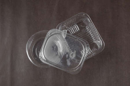 Empty plastic food boxes on dark brown backgroundの写真素材