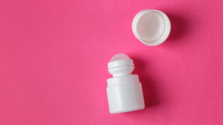White roll on deodorant with cap on pink background with copy spaceの写真素材