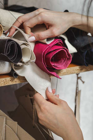 Woman choosing fabric in sewing atelier. Variety og fabric types and colors