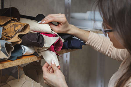 Woman choosing fabric in sewing atelier. Variety og fabric types and colorsの写真素材