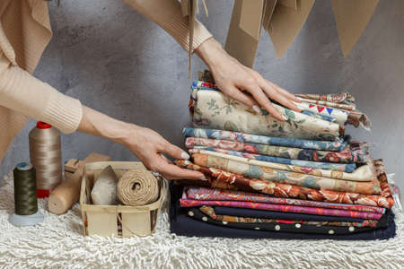 Woman choosing fabric in sewing atelier. Variety og fabric types and colors