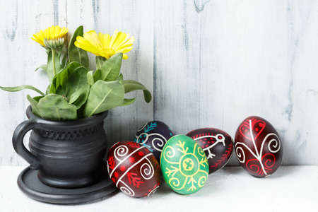 Pysanky, Ukrainian Easter eggs decorated with wax-resist dyeing technique on white wooden background