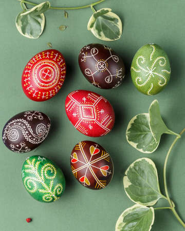 Pysanky, Ukrainian Easter eggs decorated with wax-resist dyeing technique on green background