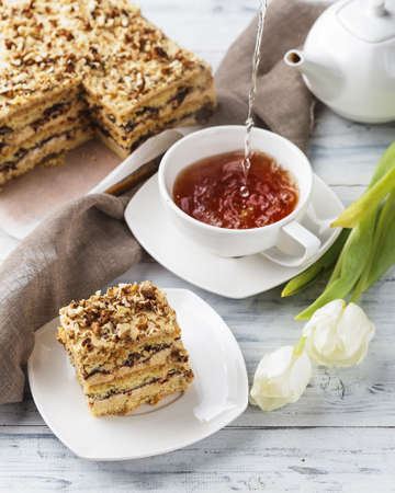 Piece of Pie with nuts and a cup of tea on a white wooden backgroundの写真素材