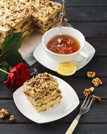 Piece of Pie with nuts and a cup of tea on a black wooden backgroundの写真素材