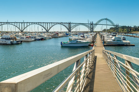 Newport, Oregon, USA - July 1, 2018: A pier and Dteel Arch Yaquina Bay Bridge in Newport, OR.のeditorial素材