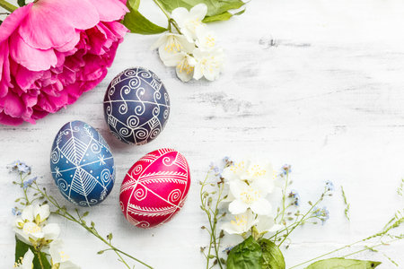 Three handmade painted Easter eggs with spring flowers. Ukrainian pysanka decorated with wax-resist...