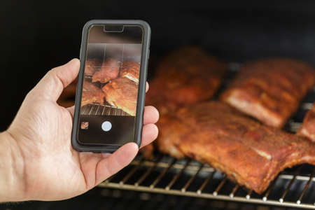 Taking photo of the Beef Ribs being cooked on Barbecue Grill. Backyard BBQ party conceptの写真素材