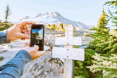 Taking Mobile Photo of the Wooden Direction Sign on the Route to the Mt. Hood Top, Oregon, USAの写真素材