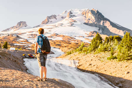 White man hiking in the snow top Mountains in the Summer. Route to the Top of Mt. Hood, Oregonの写真素材