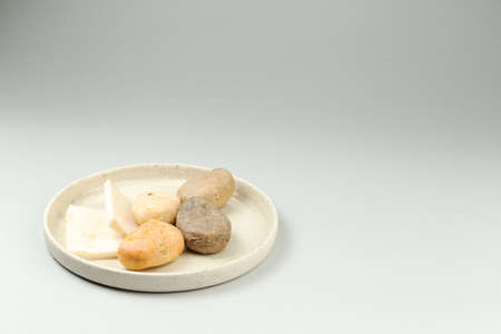 Handmade solid soap bars of different shape on white ceramic dish. Grey background with copy space for text. Zero waste, eco friendly productの写真素材