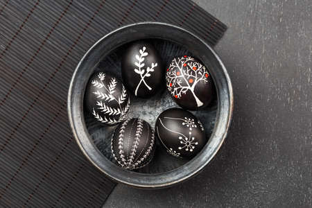 Black monochrome Easter greeting card with handmade wax dyed pysanka eggs in a bowlの写真素材
