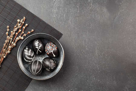 Black monochrome Easter greeting card with handmade wax dyed pysanka eggs in a bowlの写真素材