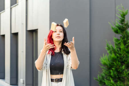 Woman juggling organic soap or solid shampoo with no packaging over gray building. Healthy lifestyle, beauty, skin care, Zero waste concept.の写真素材