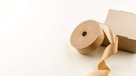 The roll of biodegradable sticky tape made of paper and cardboard box. Zero Waste Packaging Solutionの写真素材