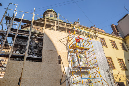 LVIV, UKRAINE - March 17, 2022: Workmen are covering the facade of the Boim Chapel in Lviv to...