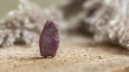 Rough Uncut Pinkish Ruby Stone on Wooden Background, Ruby is traditional popular gemstone for jewelryの写真素材