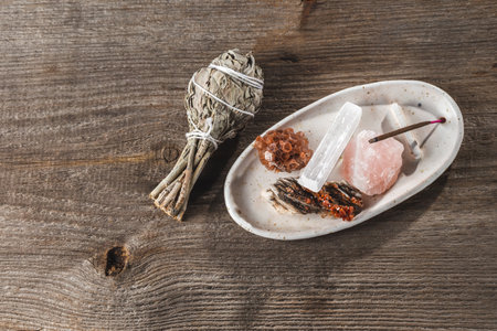 White Ceramic Incense Holder Tray with Mineral Crystal Stones and Aroma Stick and a Bundle of Salvia Sage on the Wooden Rustic Backgroundの写真素材