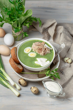 Green Cream Soup with Parsley, Sorrel and Meat Served in White Bowl with Sour Cream and Quail Eggsの写真素材