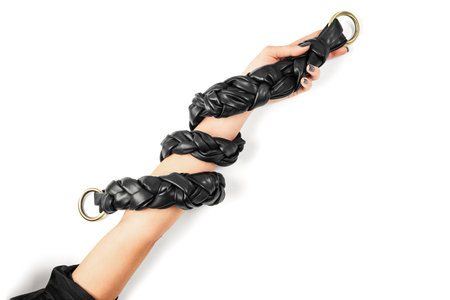 Black Genuine Leather Braided Shoulder Bag Strap Wrapped around Female Arm Isolated on White Background. Handmade Leather Goods Advertising Conceptの写真素材