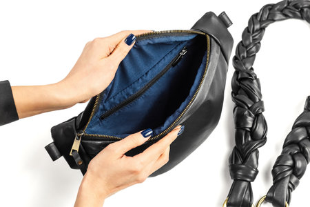Female Hands Opening Black Genuine Leather Waistbag Showing Blue Fabric Inner Lining. Handmade Leather Goods Manufactureの写真素材