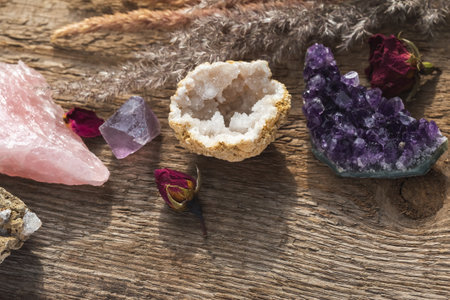 Alternative crystal healing concept. Healing Stones for Wicca Witchcraft Practice Set Up on Wooden Table with Dry Herbs and Flowers. Copy Space from the Bottom of the Compositionの写真素材