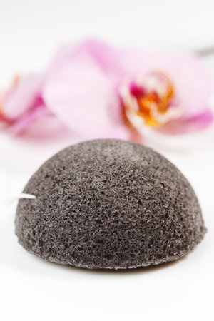 Konjac Face Cleansing Sponge with Orchid and Towel on the Backgroundの写真素材