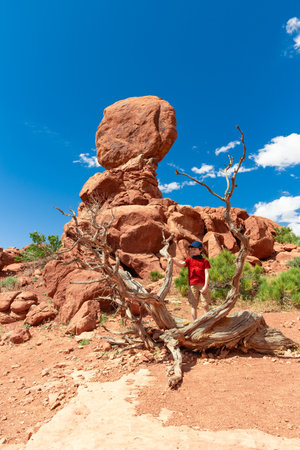 Boy near Balanced Rock in Arches National Park in Utah. Tourist Photo in the Summerの写真素材