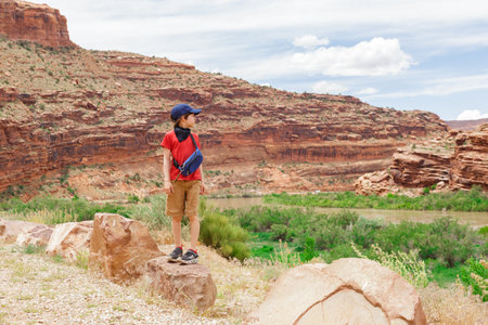 Young Hiker Boy Enjoying the View, Standing among Rock Formations in Utah, United Statesの写真素材